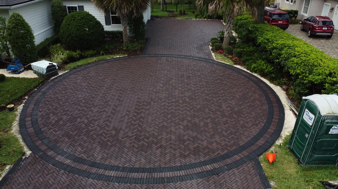 Circular paver driveway laid in a herringbone pattern with a contrasting border in St. Johns County, FL