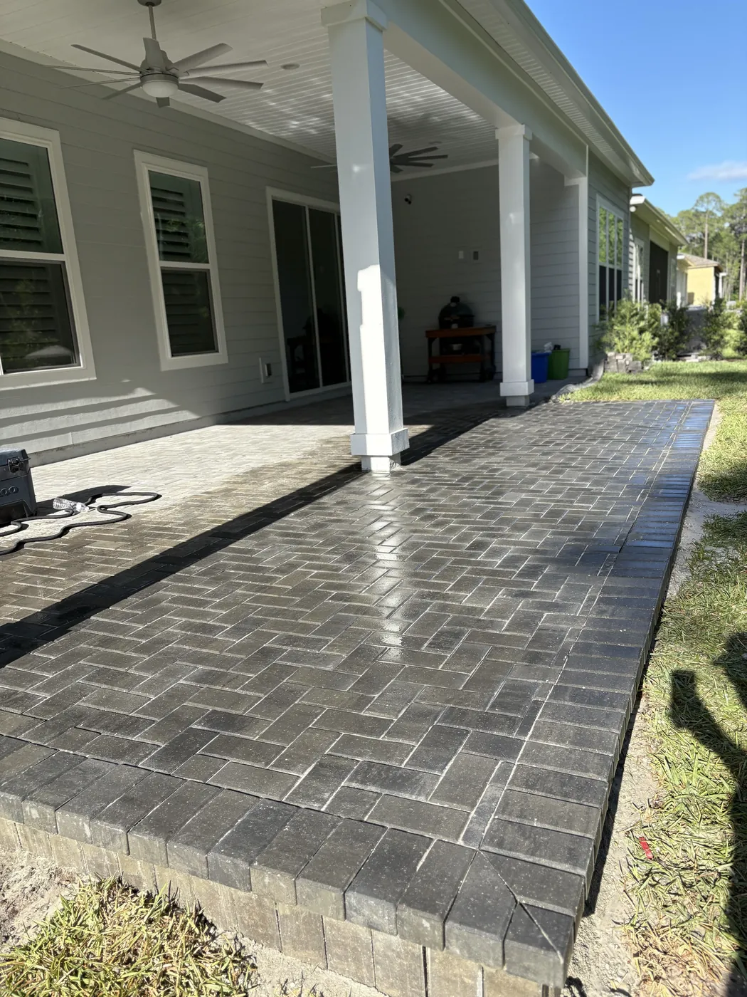 Dark grey paver patio extending from a covered lanai in St. Augustine, FL