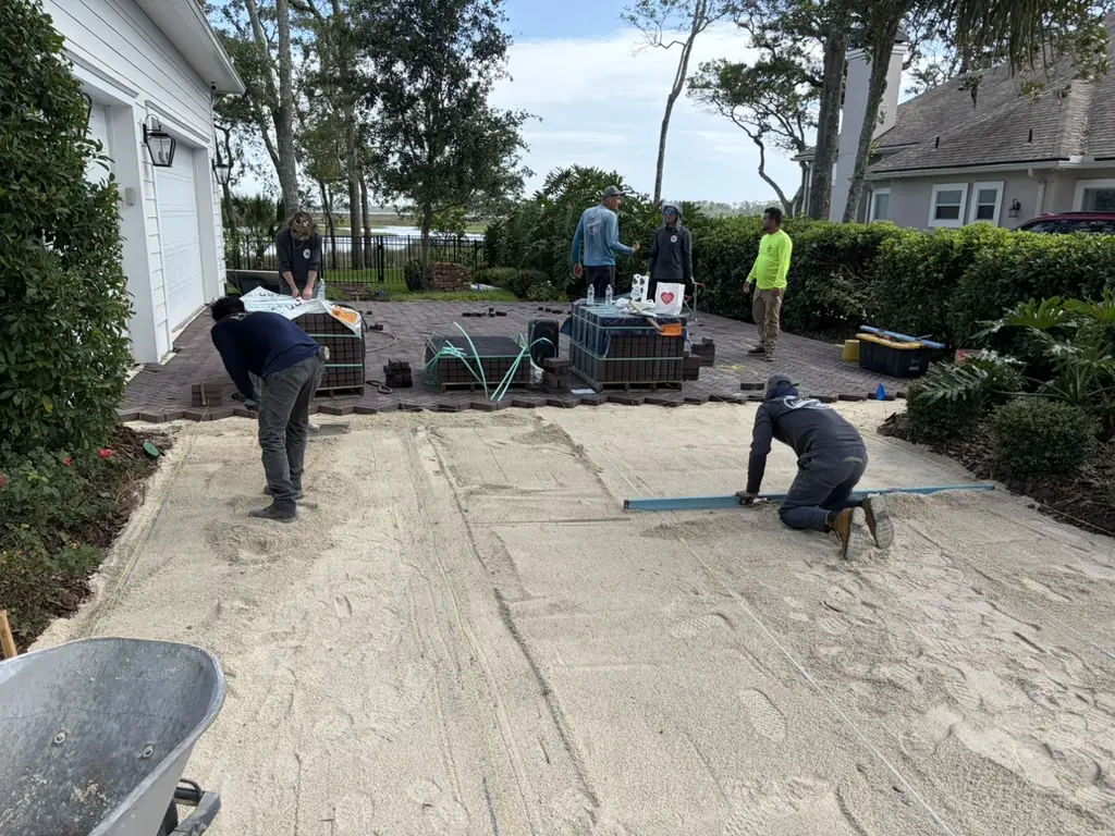 Helm crew screeding the bedding sand before laying a paver driveway in St. Augustine, FL