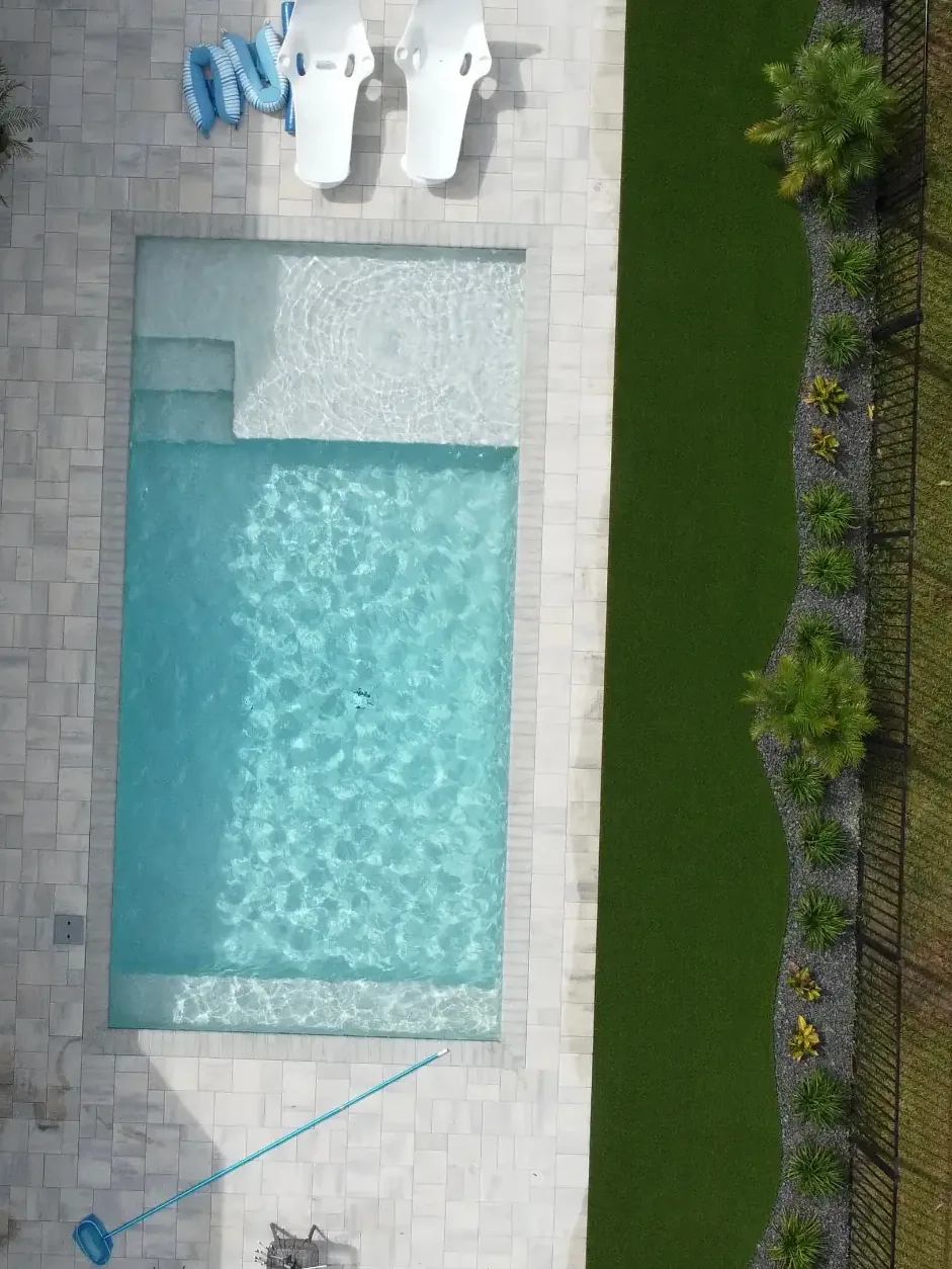 Artificial turf lawn wrapping a marble paver pool deck in St. Johns County, FL
